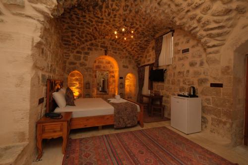 a bedroom with a bed in a stone room at Helen Olimpos Konağı in Mardin