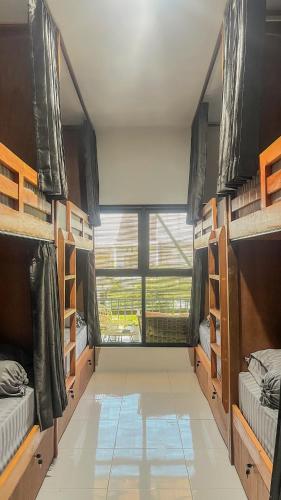 a room with many bunk beds and a large window at TWD hostel in Malang