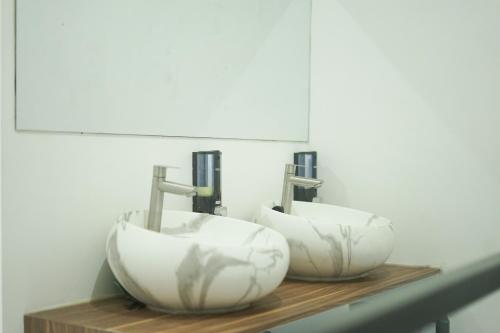 two sinks on a wooden shelf with two faucets at TWD hostel in Malang