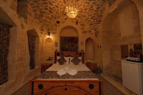 a bedroom with a bed in a stone room at Helen Olimpos Konağı in Mardin