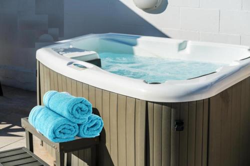 a bath tub with two blue towels in it at Lemon Tree Villa in Paralimni