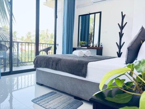a bedroom with a bed and a balcony at COCO Rooms in Galle