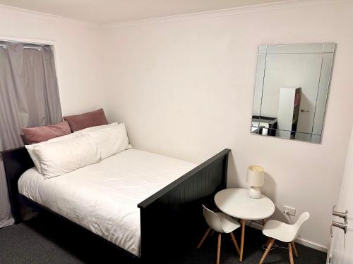 a small bedroom with a bed and a small table at Sunny Shackell - family and pet friendly in Echuca
