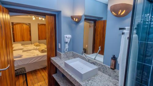 a bathroom with a sink and a bed at Ap Passarela in Porto Seguro
