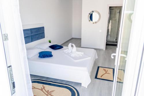 a bedroom with a white bed with blue pillows at R & A Resident in Năvodari