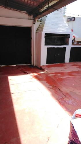 an open garage with a red floor and a building at Magda in Resistencia