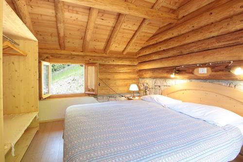 a bedroom with a bed in a wooden cabin at Baita Costa Di Gial in Lamon