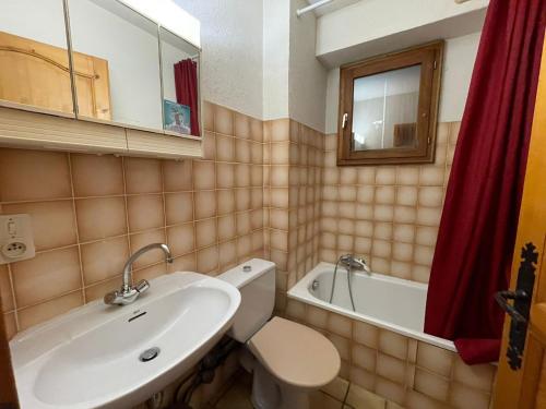 a bathroom with a sink and a toilet and a tub at Chalet Le Refuge in Samoëns