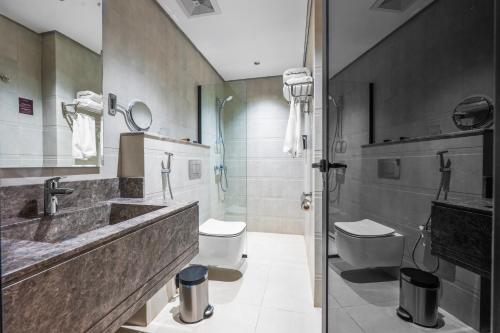 a bathroom with a sink and a toilet and a shower at Ayas Hail Hotel - فندق أياس حائل in Hail