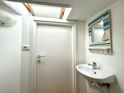 a bathroom with a white door and a sink at Sardinia Breeze - Costa Serena in Porto Rafael