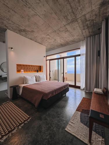 a bedroom with a large bed and a large window at Walhalla Seahouse in Chã da Igreja
