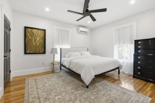 a white bedroom with a bed and a ceiling fan at Historic home on Salem Neck in Salem