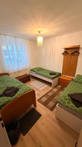 ein Zimmer mit drei Betten und einem Kronleuchter in der Unterkunft Große Monteurunterkunft Wulzeshofen in Wulzeshofen
