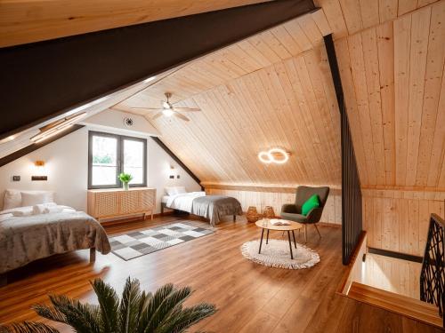 a attic bedroom with two beds and a table at Osada Puszczy Śpiew in Grotów