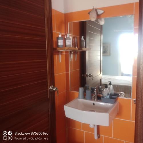 a bathroom with a sink and a mirror at Ca Azul in Tarrafal