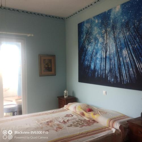 a bedroom with a bed with a large painting on the wall at Ca Azul in Tarrafal