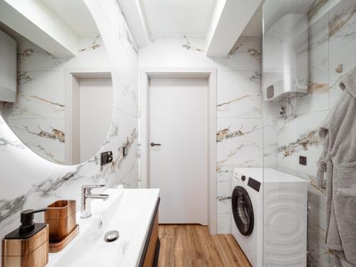 a bathroom with a washing machine and a sink at Osada Puszczy Śpiew in Grotów