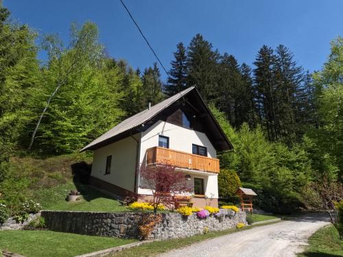 a small house on a hill with a stone wall at Holiday Home Forest Peace, Lavrovec in Hlevni Vrh