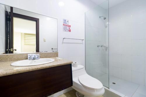 a bathroom with a toilet and a sink and a shower at Hotel Marvento Suites in Salinas