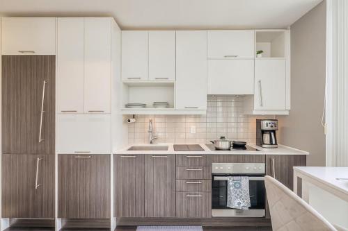 a kitchen with wooden cabinets and white appliances at CN Tower Views - 2BR Condo - Balcony - Fast Wi-Fi in Toronto
