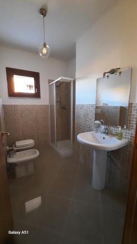 a bathroom with a sink and a shower and a toilet at Le Persiane Azzurre est in Albiano