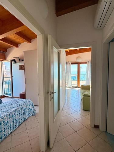 a bedroom with a bed and a view of the ocean at Monaco Apartments in Lignano Sabbiadoro
