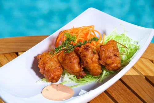 a plate of food with meatballs and vegetables on a table at Warwick Paradise Island Bahamas - All Inclusive - Adults Only in Nassau