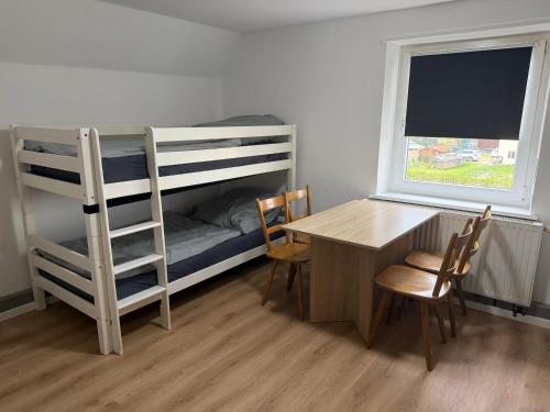 a room with a desk and a bunk bed and a table at Gasthaus Bikertreff in Gablingen