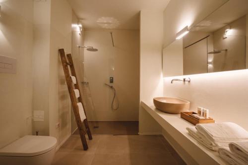 a bathroom with a sink and a toilet and a mirror at Le Ruve Bianche in Vibonati