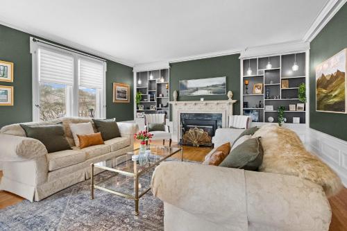 a living room with two couches and a fireplace at Historic Salyards Mansion by Heirloom Boutique Collection in Duluth