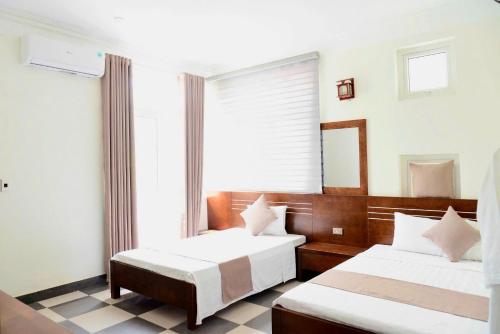 a bedroom with two beds and a window at Tigon Villa in Mỹ Ðuc