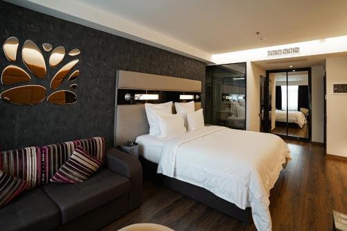 a bedroom with a large bed and a couch at 11 Mirrors Design Hotel in Kyiv