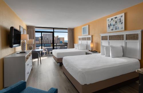 a hotel room with two beds and a television at Landmark Resort in Myrtle Beach