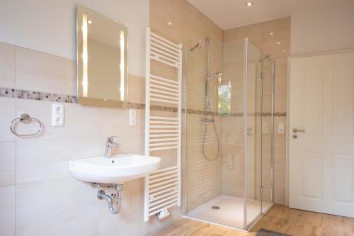 a bathroom with a sink and a shower at Ferienwohnung BEA 3 in Rabenkirchen-Faulück