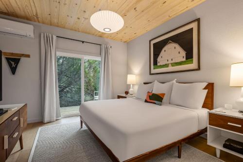 a bedroom with a large white bed and a window at Camp Jackalope - Outdoor Trails - Fire Pit - Views in Wimberley
