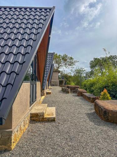 a building with a slate roof with a pathway at Riverston Basecamp in Meda-Ela