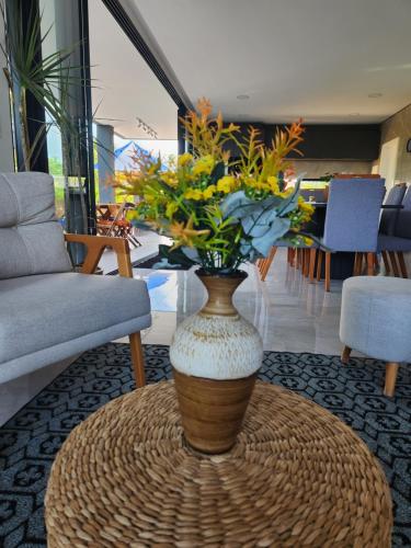 a vase with flowers on a table in a room at Casa di Palmas in Pecém