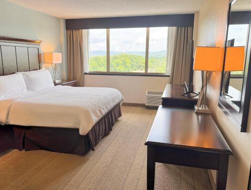 a hotel room with a bed and a large window at Holiday Inn Birmingham-Airport by IHG in Birmingham
