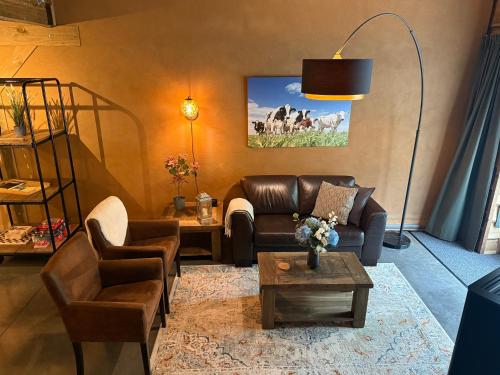 a living room with a leather couch and a table at 't Koenenhoesie in Diever