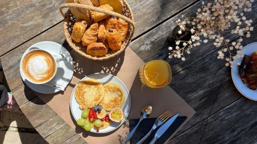 ein Tisch mit einem Teller Essen und einem Brotkorb in der Unterkunft Hôtel Chantaco Golf & Wellness in Saint-Jean-de-Luz