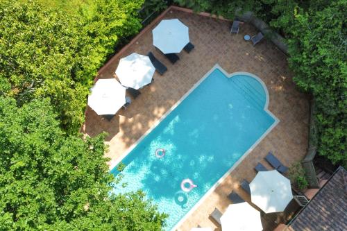 Draufsicht auf ein Schwimmbad mit Tischen und Stühlen in der Unterkunft Hôtel Chantaco Golf & Wellness in Saint-Jean-de-Luz