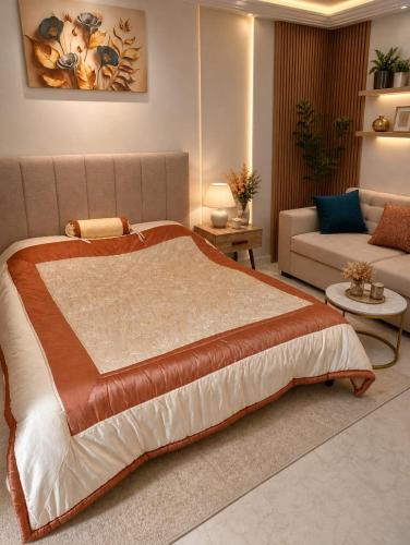 a bedroom with a large bed and a couch at Appartement chic et luxueux in Rejiche