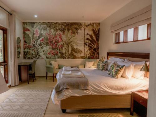 a bedroom with a bed and a painting on the wall at Tuli House in Harare