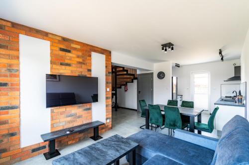 a living room and dining room with a brick wall at Morski Resort in Ustka