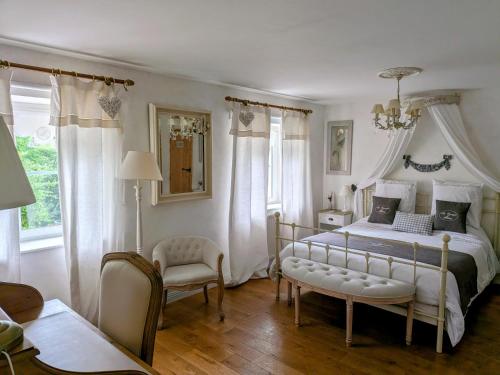 a bedroom with a large bed and a chair at La Grange d'Hélène in Cholet