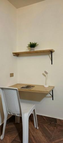 a desk with a chair and a table with a plant at Confortable apartaestudio en Ipiales in Ipiales