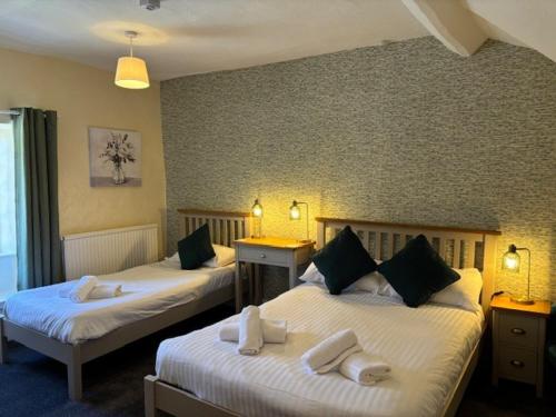 a hotel room with two beds with towels on them at The New Inn in Oswestry