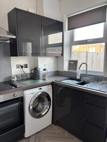 a kitchen with a washing machine and a sink at Peak Retreat in Chesterfield