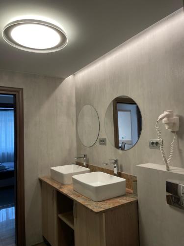 a bathroom with two sinks and a mirror at Apartamente Baile Felix in Baile Felix
