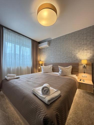 a bedroom with a large bed with a towel on it at Apartamente Baile Felix in Baile Felix